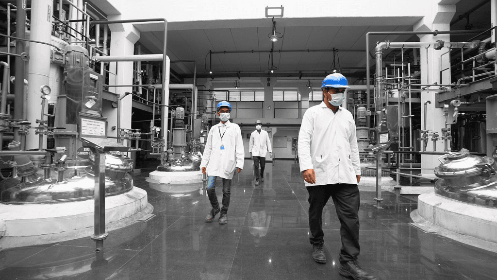 Quality control team walking through a pharmaceutical manufacturing facility