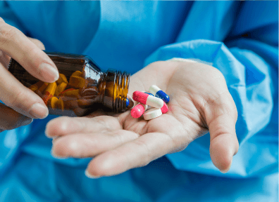 Hand pouring capsules from a bottle